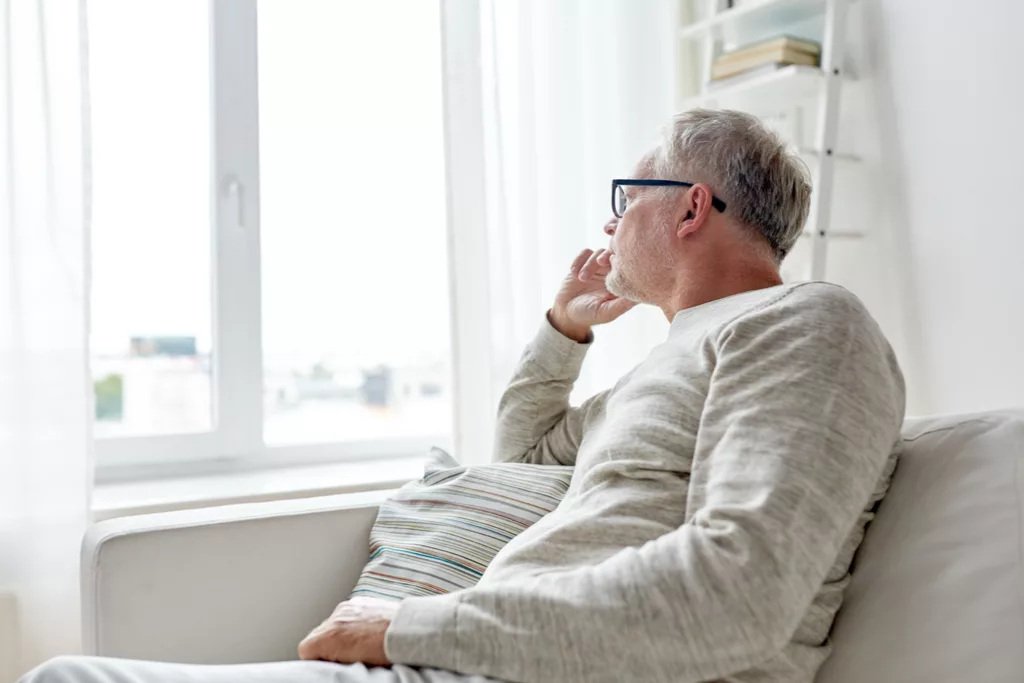 Man experiencing social isolation looking out of window